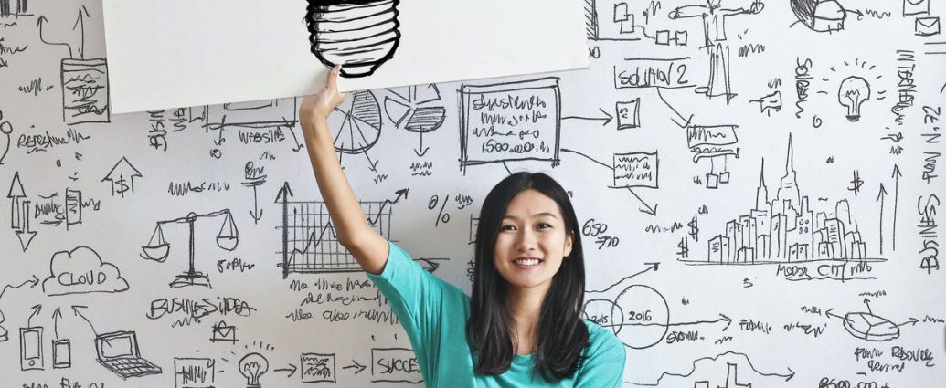woman draw a light bulb in white board