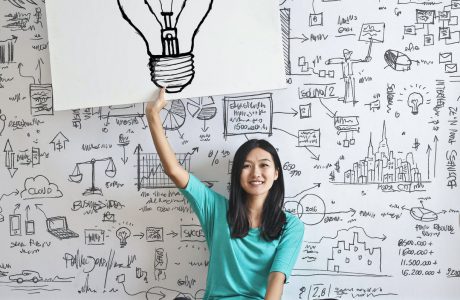 woman draw a light bulb in white board