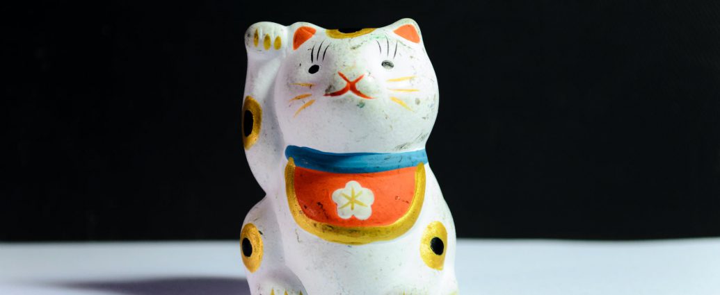 maneki neko figurine on white surface