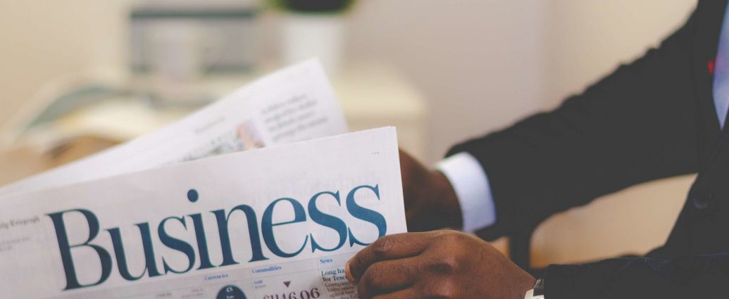 person holding white and blue business paper