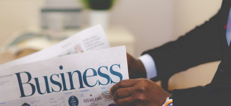 person holding white and blue business paper