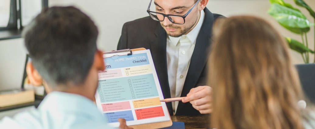 real estate agent discussing and explaining a document to a couple