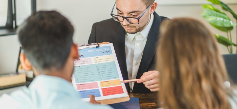 real estate agent discussing and explaining a document to a couple